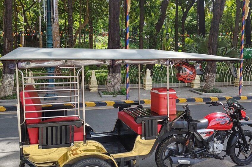 A yellow three-wheeled vehicle with a red seat and a motorcycle parked beside it. 4