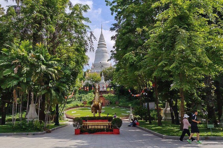 A park with a large pagoda, lush greenery, and a statue. 5