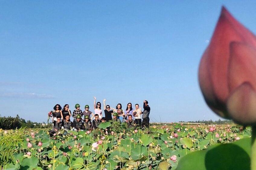 En grupp människor som står i ett fält med lotusblommor. 3