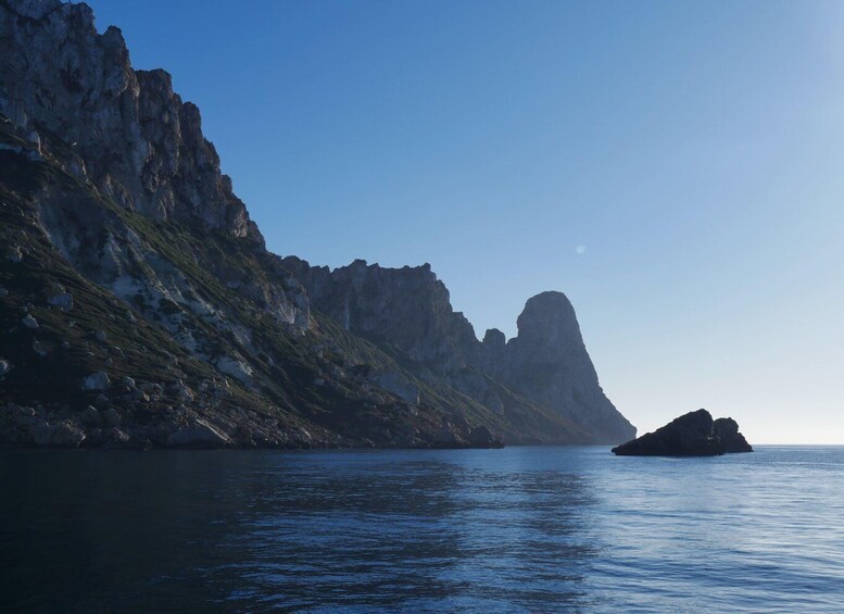 A coastal landscape with rocky cliffs and a small island. 2