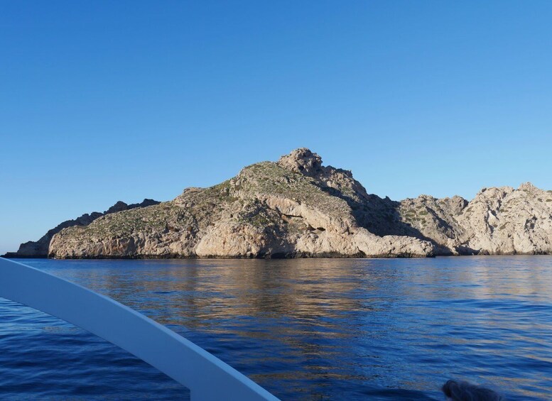 A rocky island with clear blue water in the foreground. 5