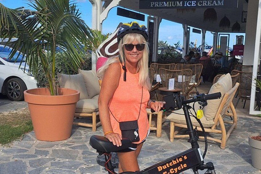 Eine Person fährt auf einem Stillstandfahrrad, neben dem ein Schild mit der Aufschrift 'Dutchie's Cycle' steht. 2