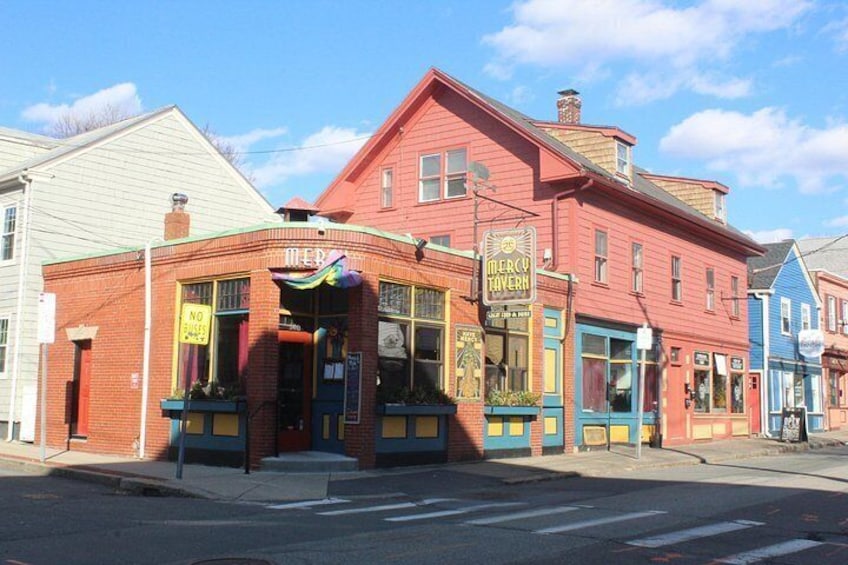 En röd byggnad med en skylt som visar texten ”Mercy Tavern”. 4