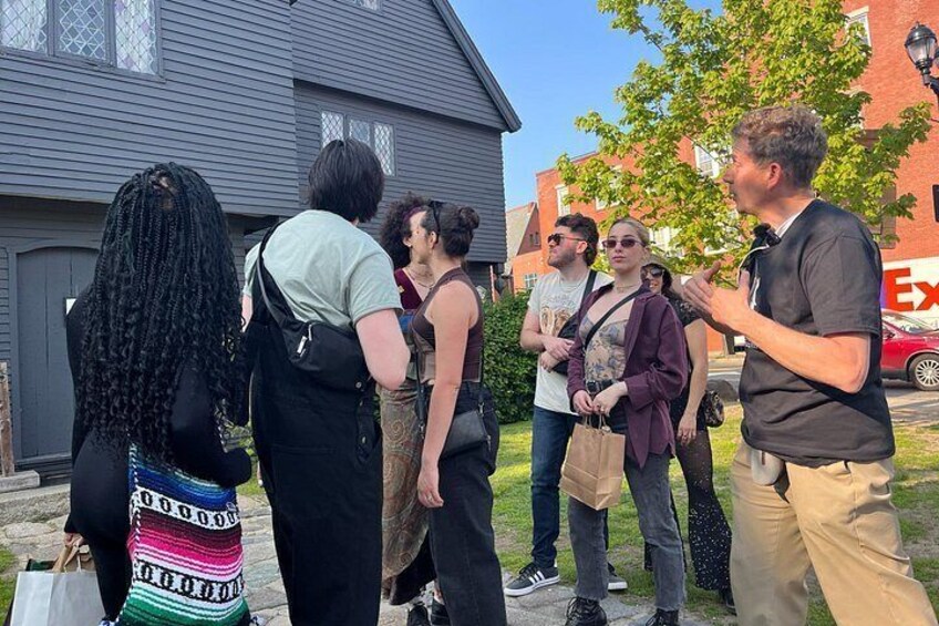 En grupp människor står utomhus och deltar i en diskussion. 2