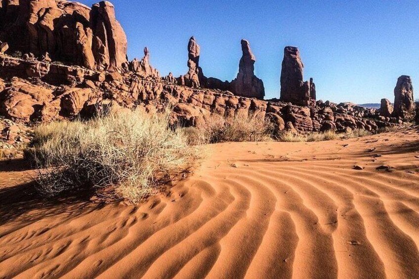 A desert landscape with sand dunes and rock formations. 2