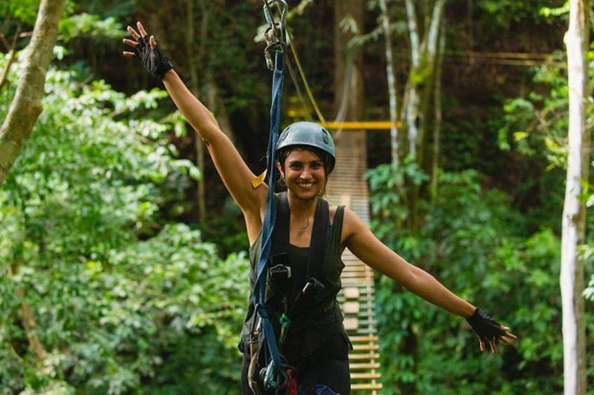A person on a zip line with a forested background. 4