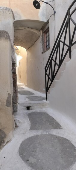 Ein schmaler Gang mit einer Treppe, einem Laternenpfahl und einem Fenster. 3