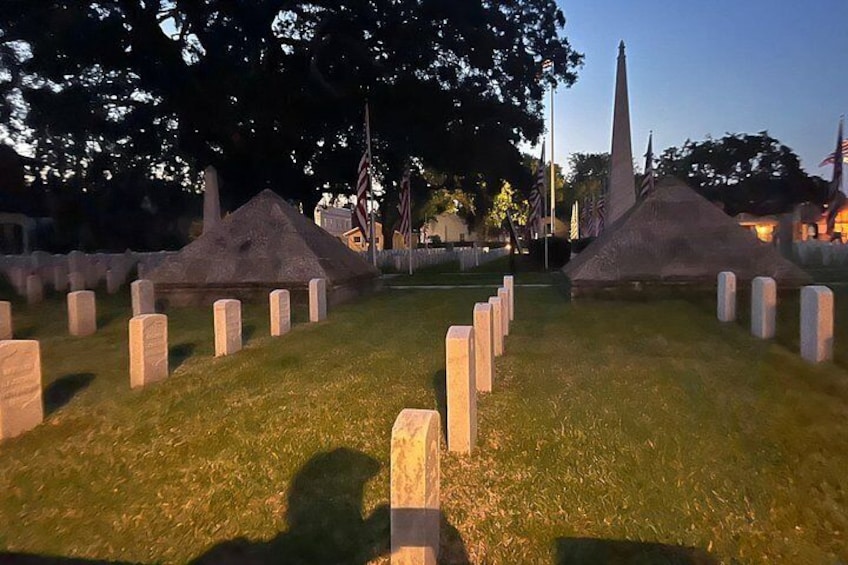 Un cementerio con lápidas y un monumento alto. 4