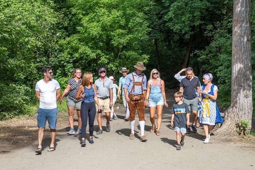 Eine Gruppe von Menschen geht auf einem Feldweg, der von Bäumen gesäumt ist. 2