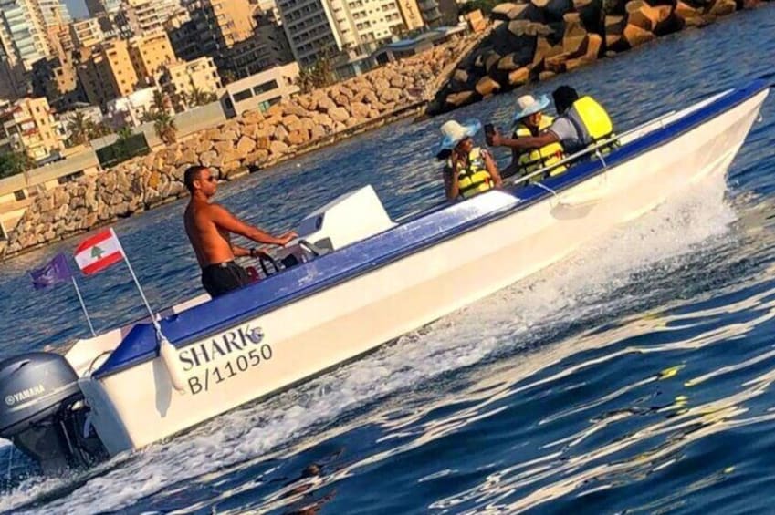 Un motoscafo con una bandiera, di nome 'SHARK B/11050', sull'acqua. 5