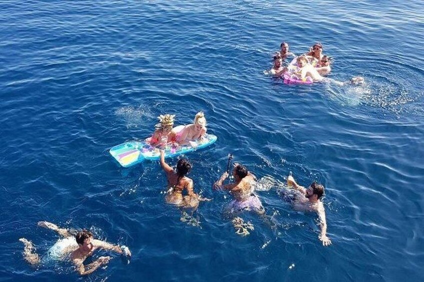 People swimming and floating on a body of water. 4