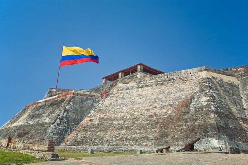 Eine große, steinerne Festung mit Fahnenmast, einer Flagge und einem kleinen Gebäude auf dem Dach. 1