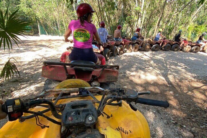 A group of people on ATVs in a forested area. 3