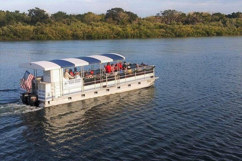 Een rivierschip met passagiers, de Amerikaanse vlag en een beboste oefer. 5