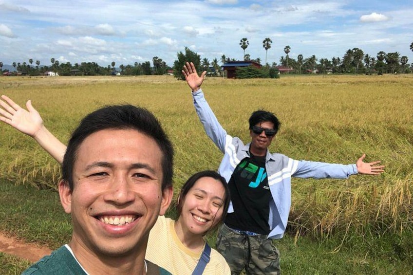 Three people standing in a field with their arms raised. 4