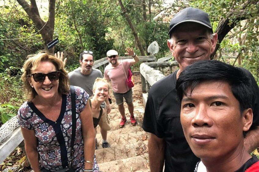 A group of people hiking on a stone path surrounded by trees. 5