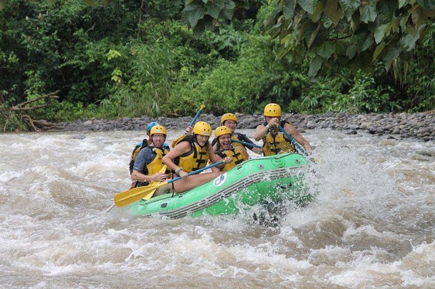 Un gruppo di persone su una zattera verde che naviga lungo un fiume. 5