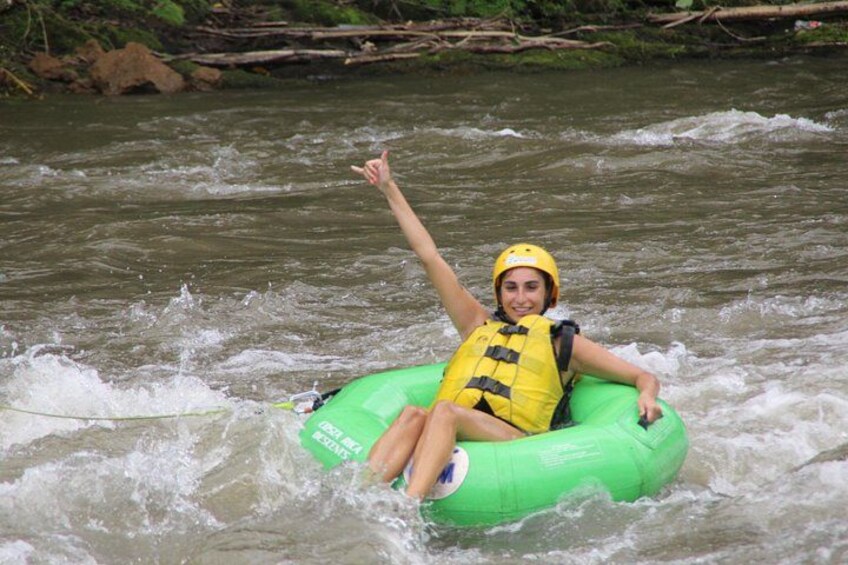 Una persona su una zattera gonfiabile verde che galleggia in un fiume. 3