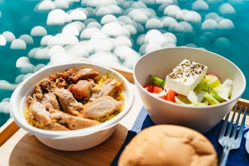 Two bowls of food, one with meat and rice, the other with vegetables and cheese, near a pool with water reflections. 2
