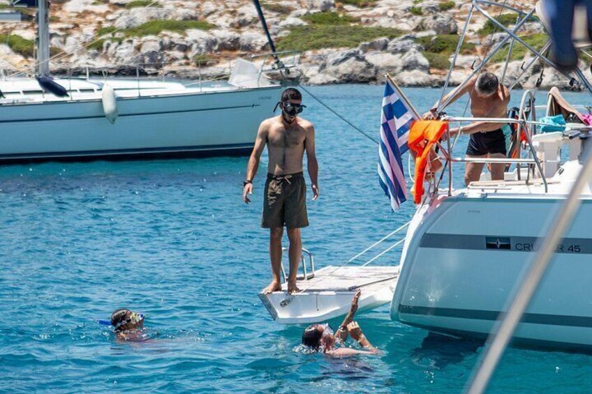 Una persona de pie en un bote, otra nadando, y un perro en el agua. 3