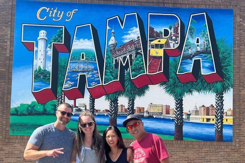 A mural of Tampa's skyline with a lighthouse, water, and palm trees. 3