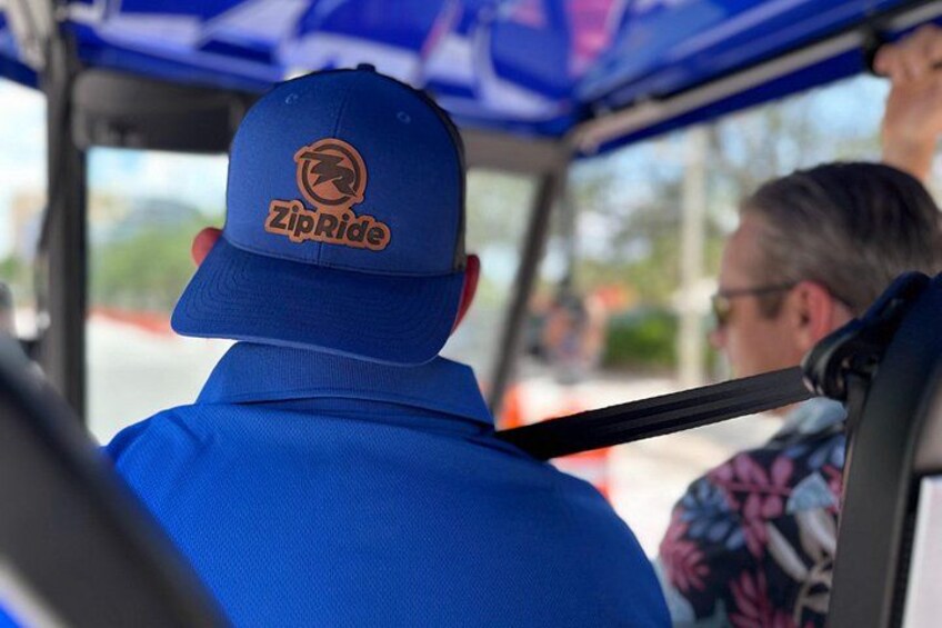 A person wearing a blue shirt and a ZipRide cap. 4