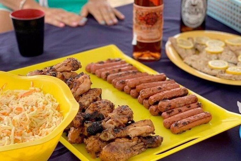 Un tavolo con carni alla griglia, insalata di cavolo e una bevanda. 4