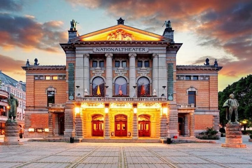 Das Nationaltheater mit klassischer Architektur, beleuchtetem Eingang und Statuen. 2