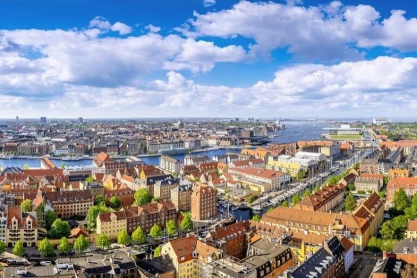 A cityscape with historic buildings, a river, and a clear sky. 1