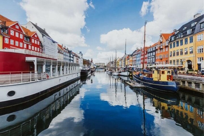 A canal with boats, colorful buildings, and a clear sky. 2