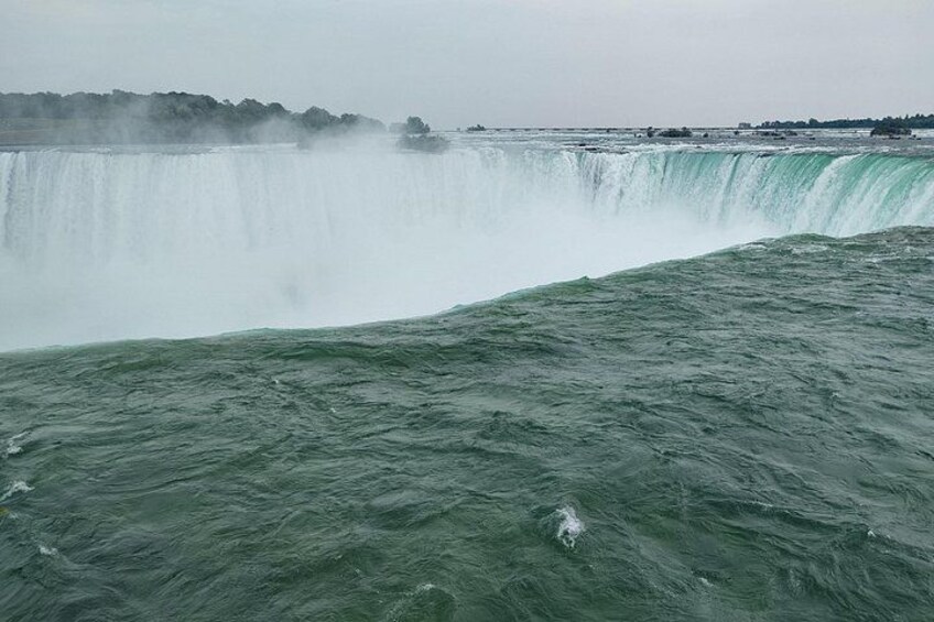 A large waterfall with water cascading down into a body of water. 5