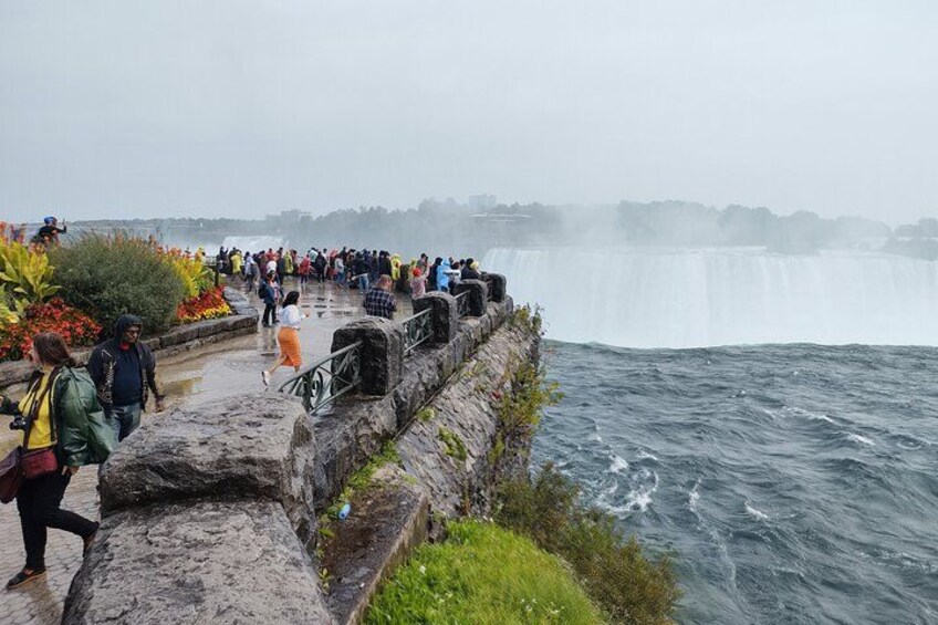A waterfall, a stone viewing platform, and people observing the scene. 3