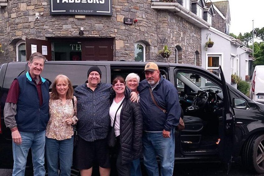 Un groupe de personnes se tient devant un bâtiment sur lequel on peut lire l’inscription « Fabb’s Bar & Restaurant ». 2