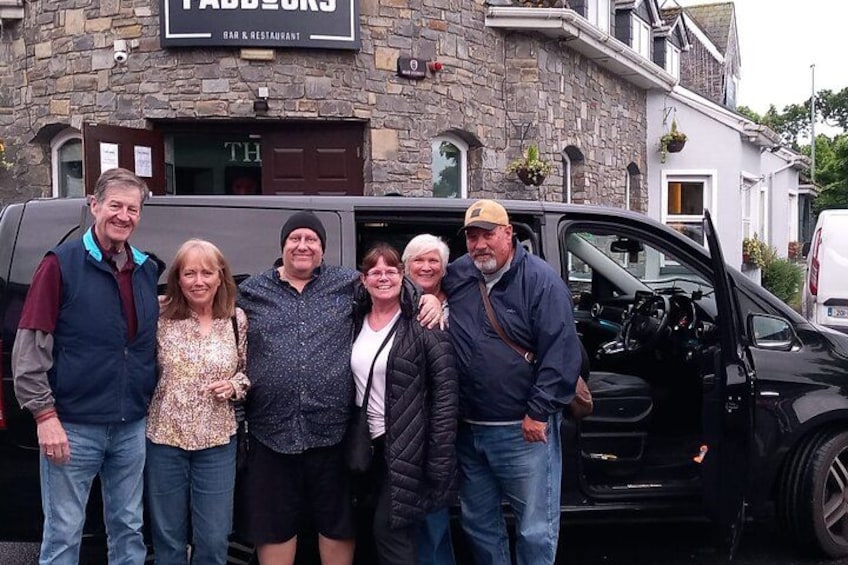 A group of people standing in front of a building with a sign that reads 'Fabb's Bar & Restaurant.' 2