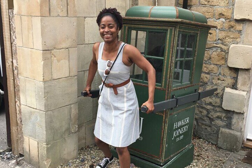 Una persona in piedi accanto a una cabina telefonica d'epoca. 2