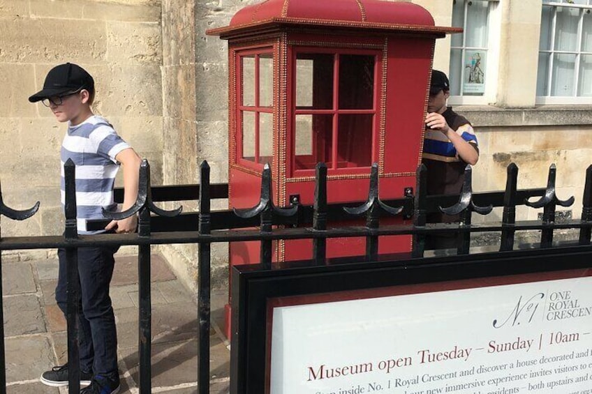 Una cabina telefónica roja y un cartel con los horarios de apertura del museo. 4