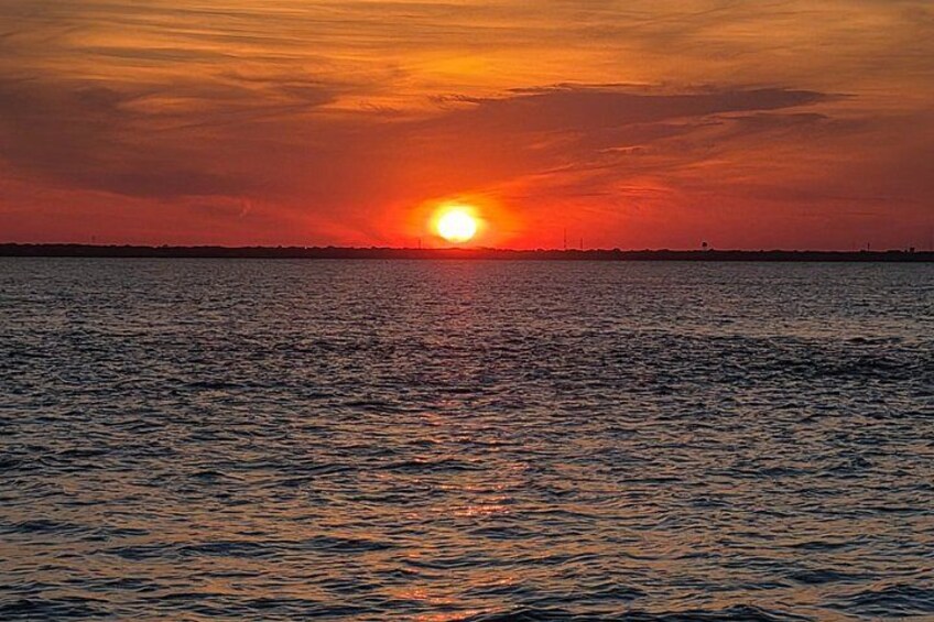 A sunset over a body of water with a horizon line. 5