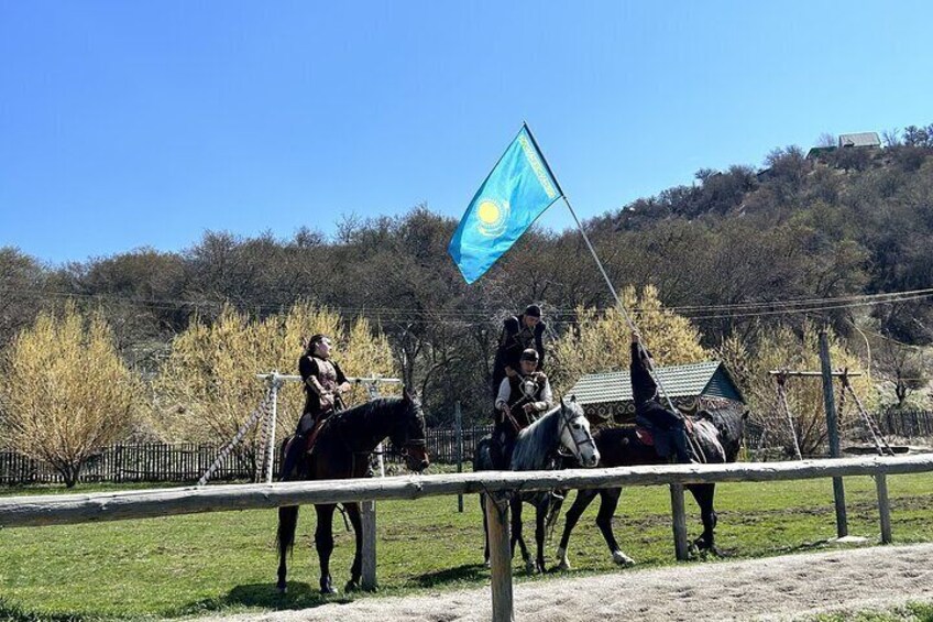 Due persone cavalcano cavalli in un'area recintata con una bandiera. 1