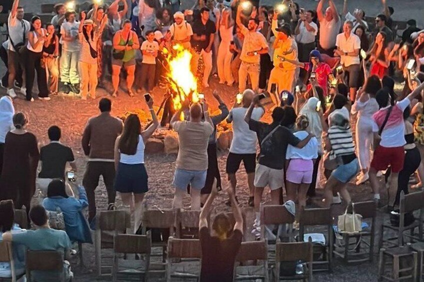 A group of people gathered around a bonfire in an outdoor setting. 1