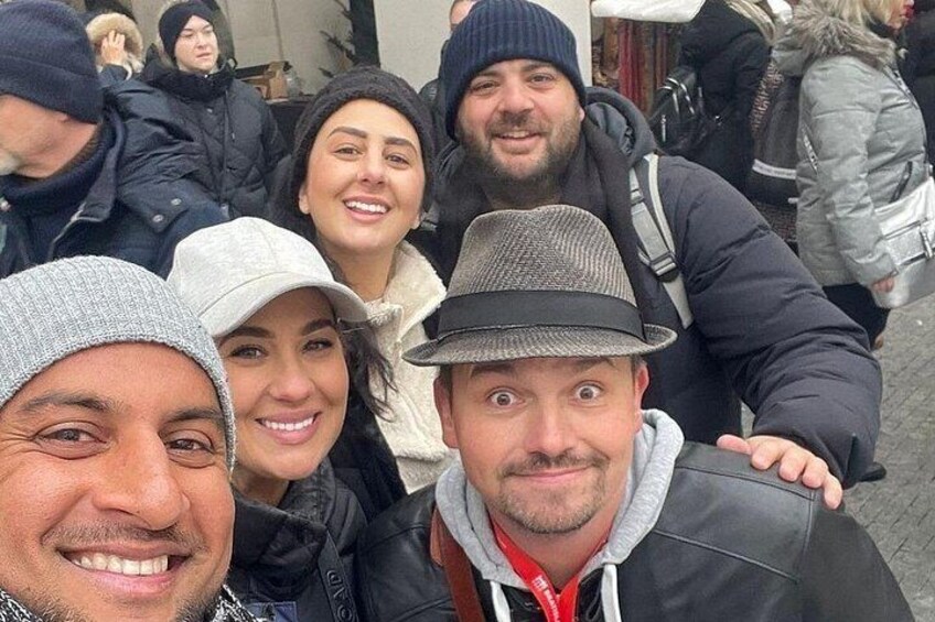 A group of people in winter clothing, some wearing hats, gathered outdoors. 2