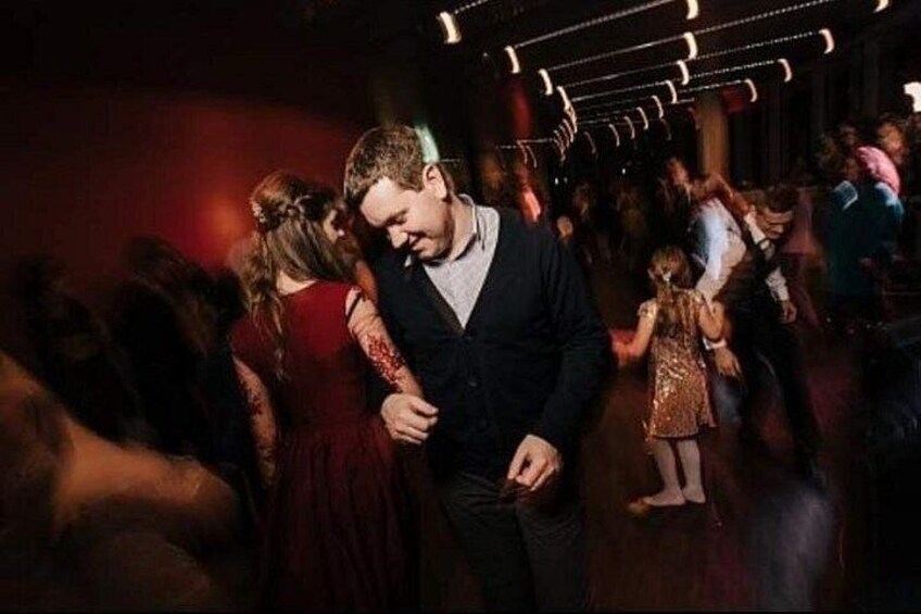 Un evento multitudinario en interiores con gente bailando e interactuando. 3