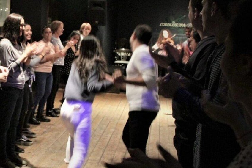 Un grupo de personas bailando sobre un piso de madera. 2