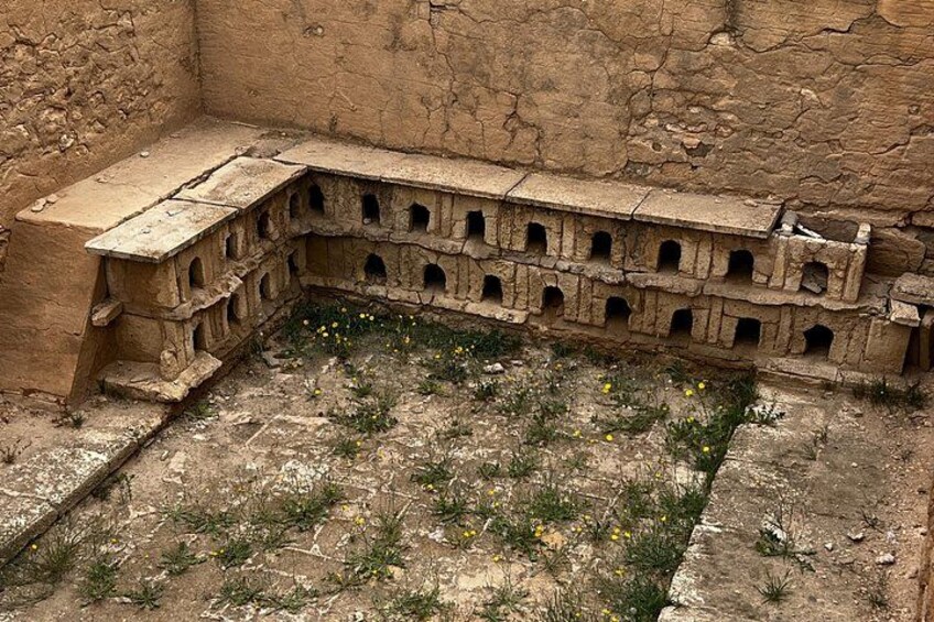 A historical structure with multiple arched openings and a flat roof. 5