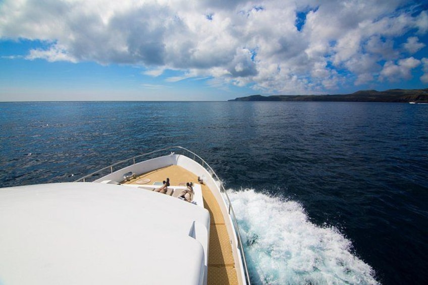 Un bateau sur l’eau, sous un ciel dégagé, avec une terre lointaine à l’horizon. 2