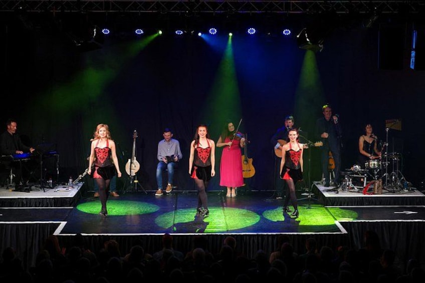 Una presentación en escenario con músicos y bailarines. 3