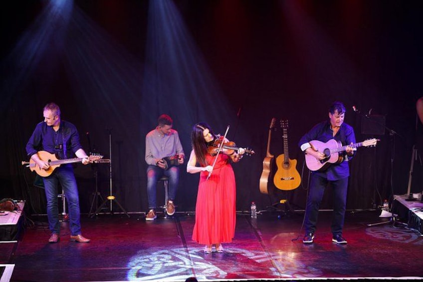 Una banda tocando en el escenario con instrumentos musicales. 4