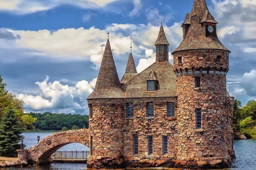A stone castle with three towers by a lake. 2