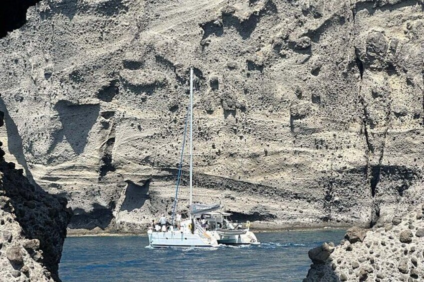 Un velero navegando por una zona costera rocosa con acantilados al fondo. 4