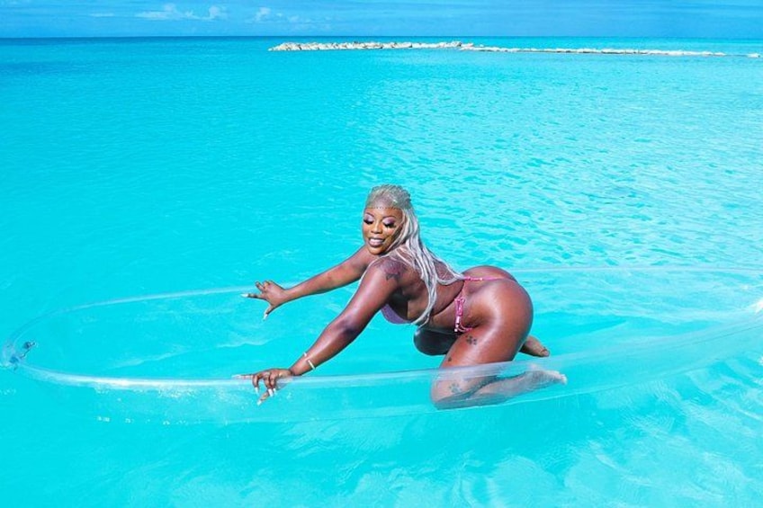 A person in a bikini on a clear blue sea with a distant island. 1