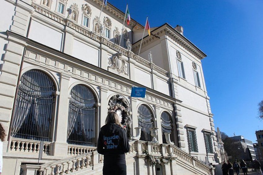 A historic building with large arched windows and a balcony. 3